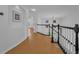 Hallway with wood flooring and a staircase featuring black banisters and white spindles at 3002 Savannah Oaks Cir, Tarpon Springs, FL 34688
