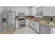 Bright kitchen featuring stainless steel appliances, granite countertops, and white cabinetry at 3002 Savannah Oaks Cir, Tarpon Springs, FL 34688