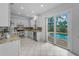 Bright kitchen features white cabinets, stainless steel appliances, granite counters and access to the outdoor pool at 3002 Savannah Oaks Cir, Tarpon Springs, FL 34688