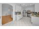 Spacious kitchen boasts white cabinets, stainless steel appliances, and granite countertops adjacent to a living area at 3002 Savannah Oaks Cir, Tarpon Springs, FL 34688