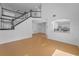 Open concept living room featuring wood floors, staircase, and an arched view of the kitchen and dining area at 3002 Savannah Oaks Cir, Tarpon Springs, FL 34688
