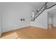 Minimalist living room features wood floors, staircase, and a wall-mounted TV bracket, with neutral tones throughout at 3002 Savannah Oaks Cir, Tarpon Springs, FL 34688