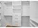 This organized walk-in closet is designed with custom shelving and drawers at 3002 Savannah Oaks Cir, Tarpon Springs, FL 34688