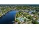 Aerial shot of a tennis and pickleball court next to a lake in a lush, tree-lined community at 314 Bath St, Tarpon Springs, FL 34689