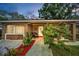 Charming single-story brick home featuring a cozy front porch with stylish outdoor seating and lush landscaping at 314 Bath St, Tarpon Springs, FL 34689