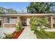 Charming single-story brick home featuring a cozy front porch with stylish outdoor seating and lush landscaping at 314 Bath St, Tarpon Springs, FL 34689