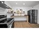Modern kitchen featuring stainless steel appliances, wood-look tile floors, and updated lighting at 314 Bath St, Tarpon Springs, FL 34689