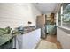 Well-lit laundry area featuring a stainless steel refrigerator, sink, wooden shelves, and greenery at 314 Bath St, Tarpon Springs, FL 34689