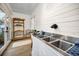 Bright laundry room features shiplap walls, wood look floors, sink, shelf, and access to the exterior at 314 Bath St, Tarpon Springs, FL 34689