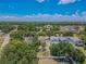 Aerial view of homes showcasing the backyard with a tiki bar, shed, and mature trees at 316 Lafayette Blvd, Oldsmar, FL 34677