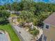Aerial view of the backyard with tropical landscaping, tiki bar, seating area, and shed at 316 Lafayette Blvd, Oldsmar, FL 34677