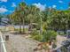 This backyard features tropical landscaping, a tiki bar, lounging area, and a white privacy fence at 316 Lafayette Blvd, Oldsmar, FL 34677