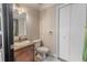 Bathroom featuring single sink vanity, tile flooring, and a matching toilet and white linen closet at 316 Lafayette Blvd, Oldsmar, FL 34677