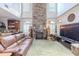 Open-concept living space featuring a stone fireplace, vaulted ceilings, leather seating, and ample natural light at 316 Lafayette Blvd, Oldsmar, FL 34677
