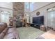 Spacious living room featuring a floor-to-ceiling stone fireplace, vaulted ceilings, and comfortable leather seating at 316 Lafayette Blvd, Oldsmar, FL 34677