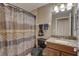 Bathroom features a granite-topped vanity and shower with patterned curtain at 3338 Laurelwood Ct, Tarpon Springs, FL 34688