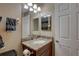 Bathroom features a granite topped vanity, mirror, and sink at 3338 Laurelwood Ct, Tarpon Springs, FL 34688