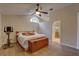 Bright bedroom features a wood accent chest, ceiling fan, and ensuite bathroom with glass shower at 3338 Laurelwood Ct, Tarpon Springs, FL 34688