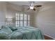 Bright bedroom with natural light from shuttered windows, a ceiling fan and soft, comfortable decor at 3338 Laurelwood Ct, Tarpon Springs, FL 34688