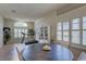 Bright dining area featuring large windows with shutters, neutral flooring, and a modern table at 3338 Laurelwood Ct, Tarpon Springs, FL 34688