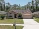 Charming single-story home featuring a well-manicured lawn and an attached two-car garage at 3338 Laurelwood Ct, Tarpon Springs, FL 34688