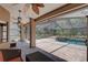 Inviting screened lanai featuring brick flooring, a ceiling fan, and a beautiful pool and spa at 3338 Laurelwood Ct, Tarpon Springs, FL 34688