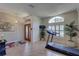Bright living area featuring a treadmill, large windows with shutters, and neutral flooring at 3338 Laurelwood Ct, Tarpon Springs, FL 34688
