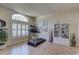 Bright living area featuring a treadmill, large windows with shutters, and a decorative bookcase at 3338 Laurelwood Ct, Tarpon Springs, FL 34688