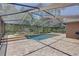 Sparkling screened pool and spa area surrounded by brick pavers and lush landscaping at 3338 Laurelwood Ct, Tarpon Springs, FL 34688
