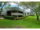 Well-maintained condo building surrounded by lush green lawns and shade trees at 36750 Us 19 N # 24-211, Palm Harbor, FL 34684