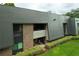 View of an exterior building featuring a balcony, lush landscaping, and a grass area at 36750 Us 19 N # 24-211, Palm Harbor, FL 34684