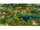 Aerial view of a scenic golf course featuring a pond and lush green fairways at 36750 Us 19 N # 24-211, Palm Harbor, FL 34684