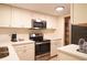 Kitchen featuring stainless steel appliances including an oven, range and microwave, as well as white cabinets at 36750 Us 19 N # 24-211, Palm Harbor, FL 34684