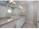 Bathroom with double sink vanity with granite countertops and a glass enclosed shower at 3906 N Lynn Ave, Tampa, FL 33603