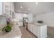 Bright kitchen features white cabinets, stainless steel appliances, and an island with a granite countertop at 3906 N Lynn Ave, Tampa, FL 33603