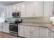 This kitchen showcases stainless steel appliances, white cabinets, granite countertops, and tile backsplash at 3906 N Lynn Ave, Tampa, FL 33603