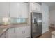 Kitchen boasts stainless steel refrigerator, white cabinets, granite countertops, and tile backsplash at 3906 N Lynn Ave, Tampa, FL 33603