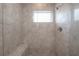 Shower featuring neutral tiles, built-in bench, and bright window at 3906 N Lynn Ave, Tampa, FL 33603