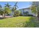Spacious backyard with lush green lawn, mature trees, and landscaped garden beds at 405 S Shore Crest Dr, Tampa, FL 33609