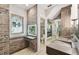 Modern bathroom with brick accent wall, dual sinks, and a glass-enclosed toilet room at 405 S Shore Crest Dr, Tampa, FL 33609