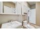 Bright bathroom features a white pedestal sink, toilet, medicine cabinet, and white shaker storage at 405 S Shore Crest Dr, Tampa, FL 33609