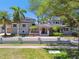 Elegant two-story home featuring a tile roof, manicured landscaping, and a secure wrought iron fence at 405 S Shore Crest Dr, Tampa, FL 33609