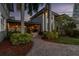 Back exterior of a beautiful home with brick pavers, lush landscaping, and an outdoor kitchen at 405 S Shore Crest Dr, Tampa, FL 33609
