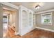 Well-lit office space with custom built-in shelving, hardwood floors, and archway access at 405 S Shore Crest Dr, Tampa, FL 33609