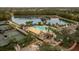 Aerial view of a community pool, tennis courts, lake, and wooded areas offering a variety of recreational opportunities at 4056 Southern Valley Loop, Brooksville, FL 34601
