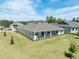 Serene home exterior displaying a wide lawn and neat landscaping under a brilliant blue sky with scattered clouds at 4056 Southern Valley Loop, Brooksville, FL 34601