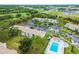 Overhead view of condo community near a highway, showcasing a swimming pool and parking with surrounding green spaces at 413 Meadow Ln # 81, Oldsmar, FL 34677