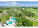 Aerial view showing a community pool, clubhouse, and golf course surrounded by mature trees and landscaping at 413 Meadow Ln # 81, Oldsmar, FL 34677