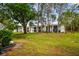View of condo from backyard featuring patio furniture, lush greenery, and serene outdoor living space at 413 Meadow Ln # 81, Oldsmar, FL 34677