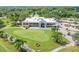 Exterior shot of the clubhouse and putting green with well-manicured lawns and palm tree landscaping at 413 Meadow Ln # 81, Oldsmar, FL 34677